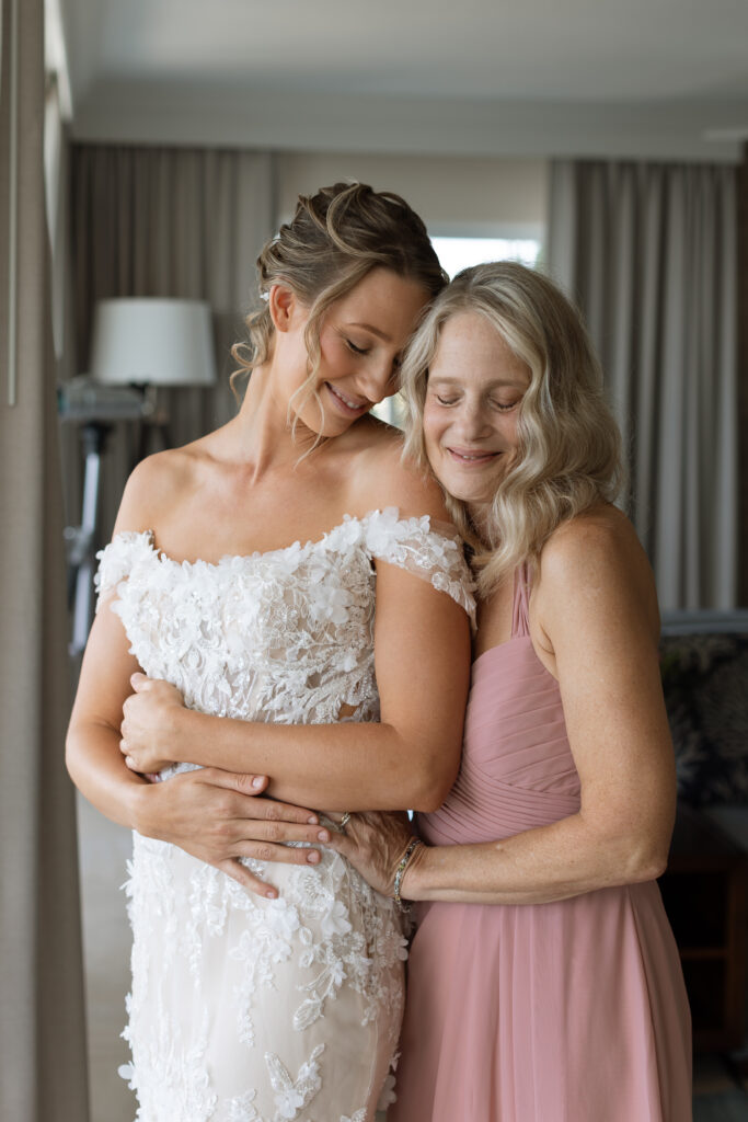 Bride's mom helping bride in her wedding gown