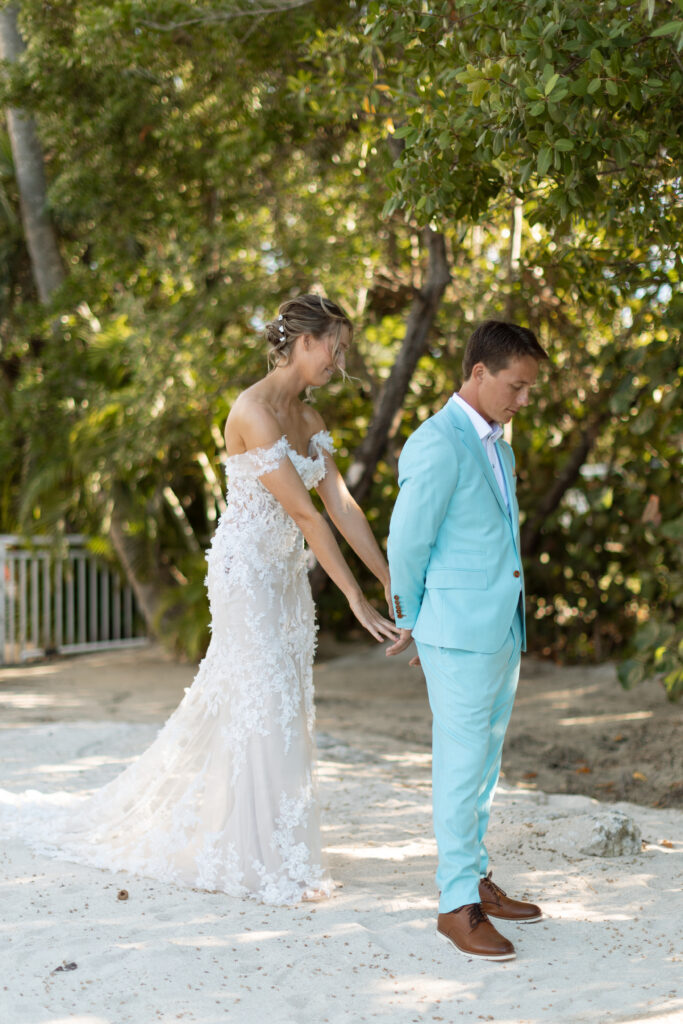 Bride and groom have their first look at The Reefhouse in Key Largo, Florida, with tropical greenery as their backdrop.