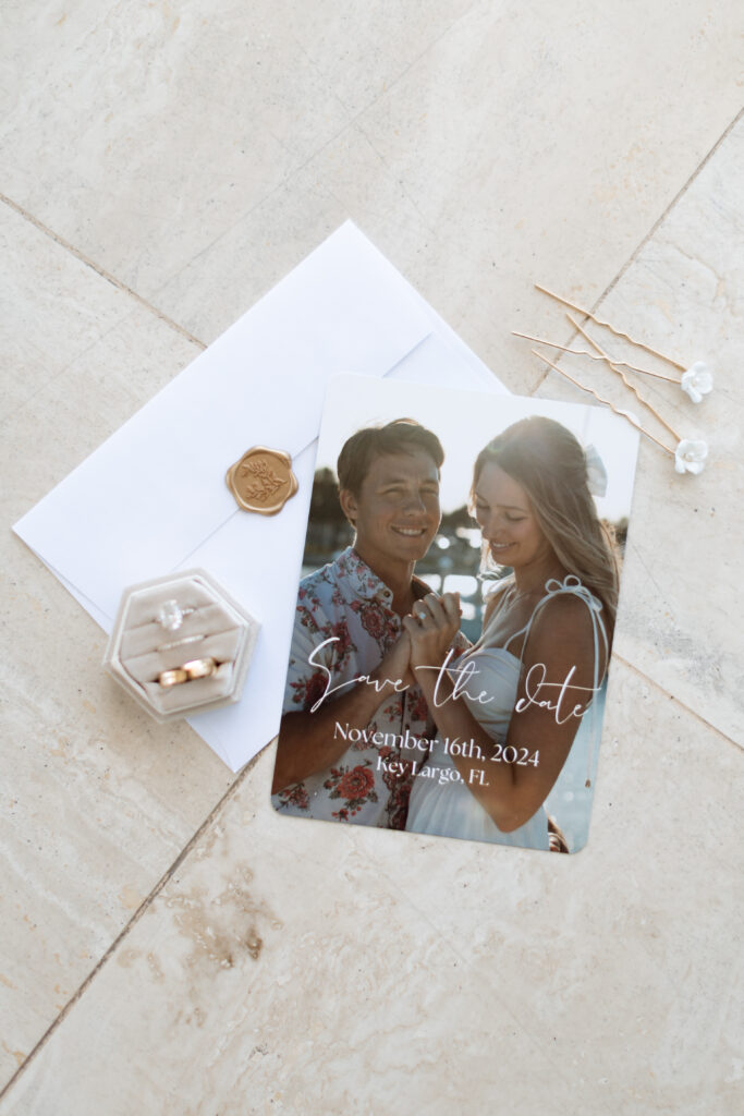 Close-up of the wedding invitation and rings at The Reefhouse in Key Largo, with soft sunlight filtering through the windows, captured by The Deans Photography