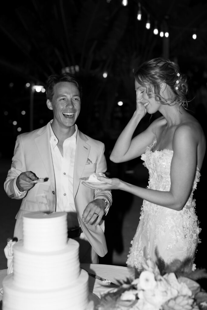 Couple cutting their stunning tropical wedding cake, set against the backdrop of The Reefhouse Resort in Key Largo, Florida