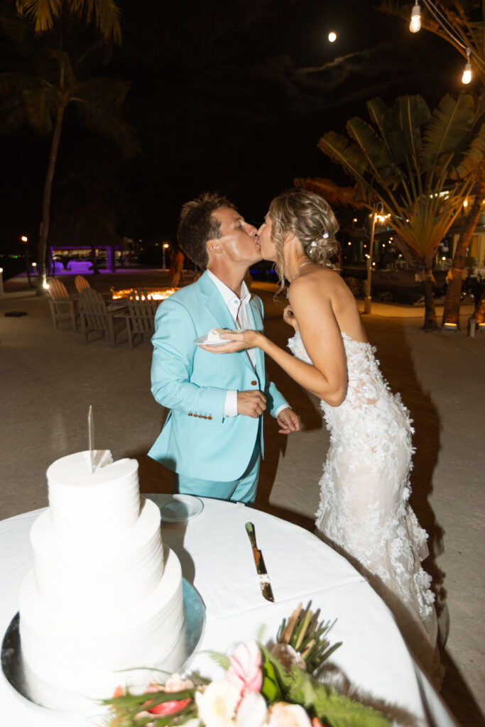 Couple cutting their stunning tropical wedding cake, set against the backdrop of The Reefhouse Resort in Key Largo, Florida