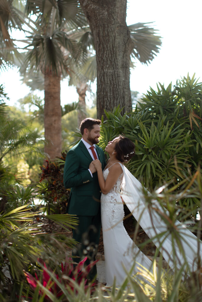 Bride and groom captured by The Deans Photography at Paradise Cove, with a stunning backdrop of Lake Buena Vista and tropical palm trees surrounding them.