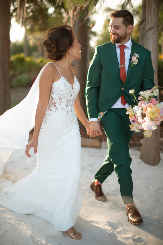 Romantic sunset portrait of the bride and groom at Paradise Cove, photographed by The Deans Photography, with vibrant colors in the sky and serene lake views.