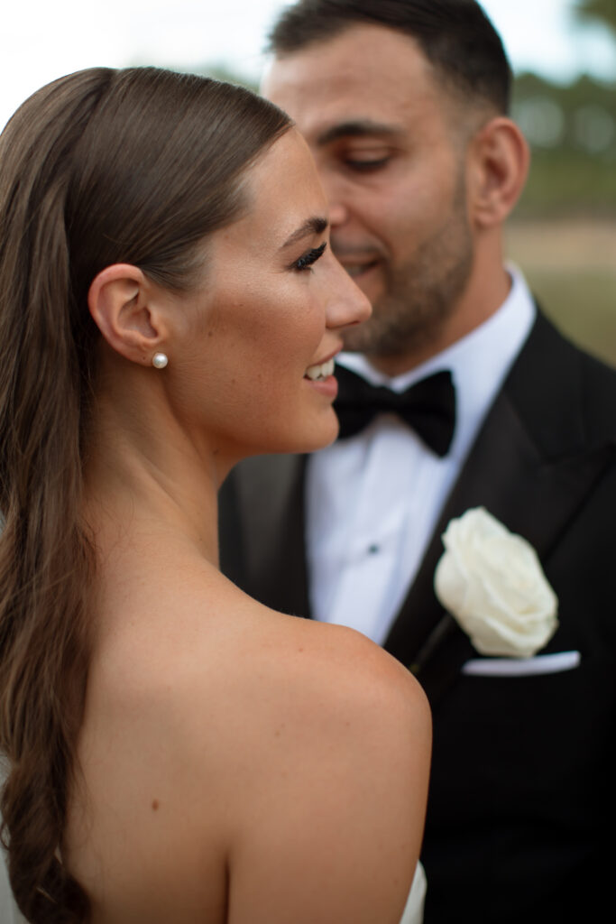 Bride and groom posing for a stunning wedding portrait at Disney's Four Seasons Resort Orlando, captured by The Deans Photography, with elegant architecture and manicured gardens in the background.