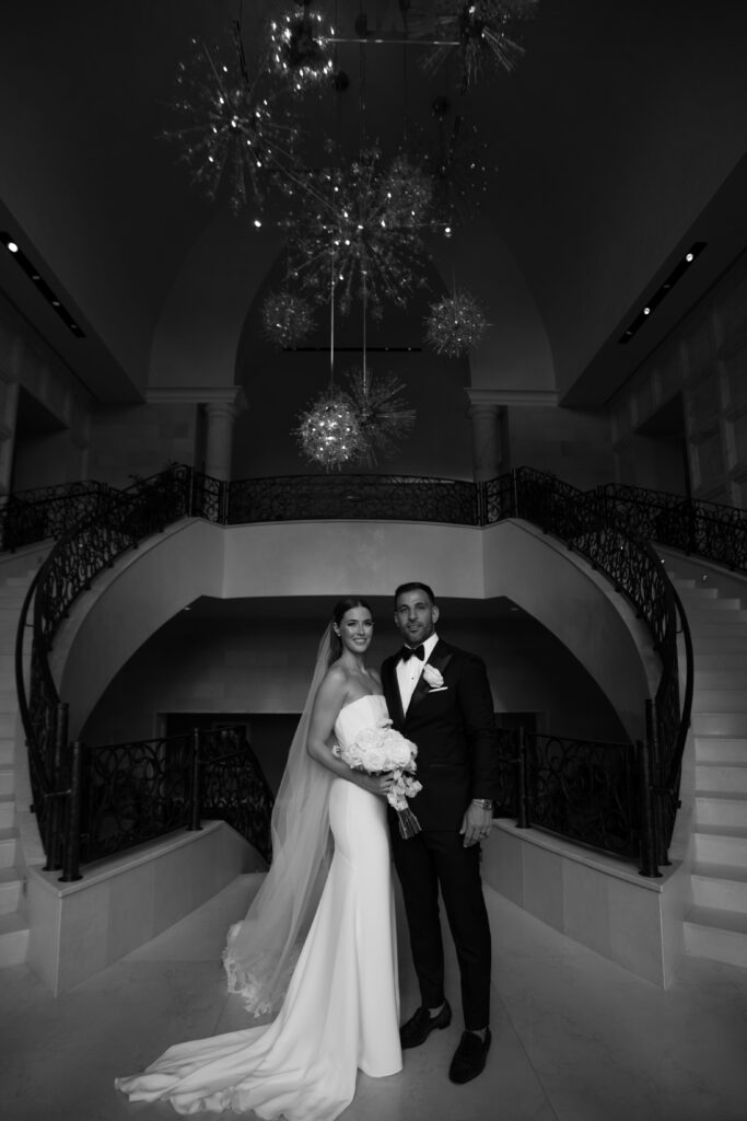 Bride and groom posing for a stunning wedding portrait at Disney's Four Seasons Resort Orlando, captured by The Deans Photography, with elegant architecture and manicured gardens in the background.