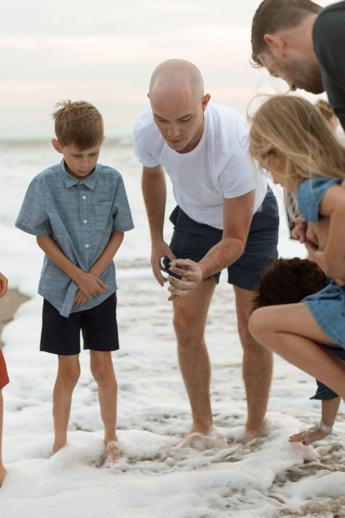 Parents and children laughing together on Melbourne Beach, during a sunrise family photography session.