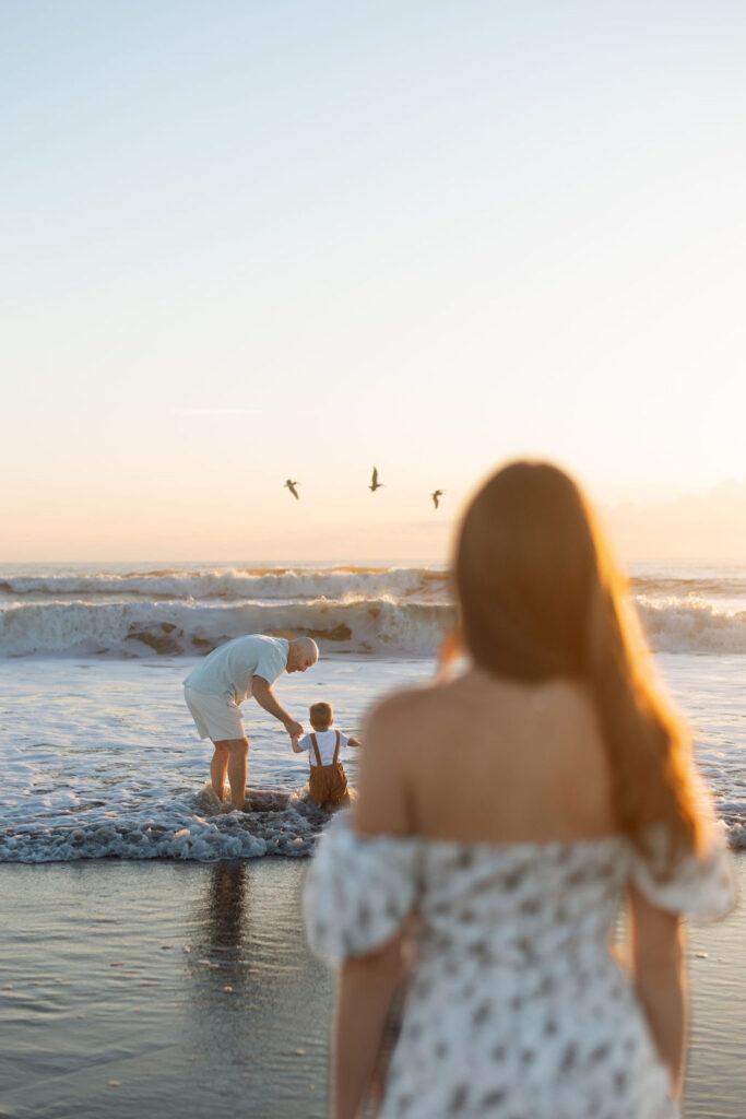 Mom watching her husband and son play in the waves in Cocoa Beach, Florida.