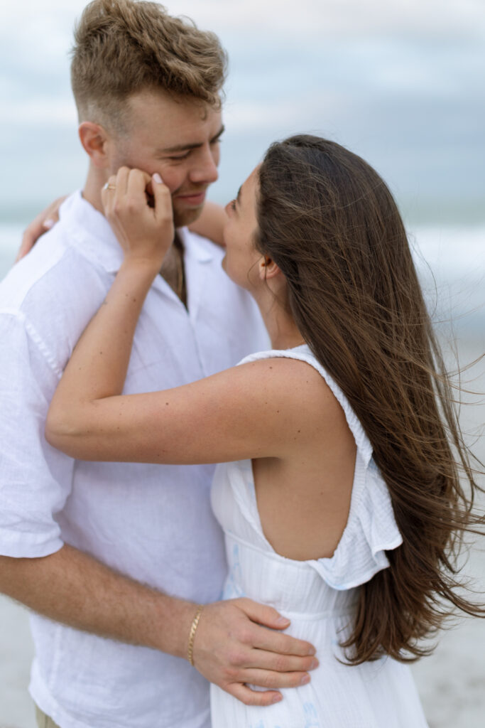 Candid photo of couple laughing on Cocoa Beach at sunset, captured naturally by The Deans Photo during golden hour.