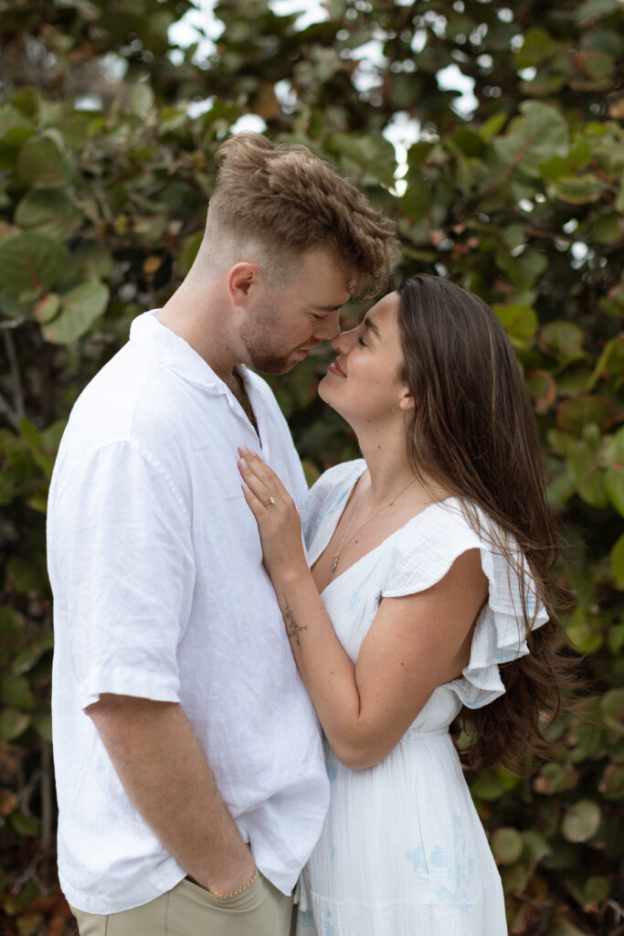 Engaged couple enjoying a quiet, intimate moment on Cocoa Beach at sunset, beautifully captured by The Deans Photography.