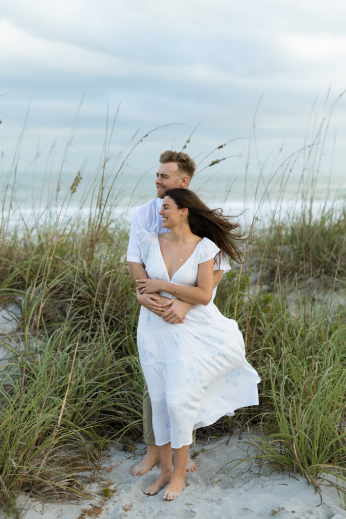 Romantic close-up of couple embracing on Cocoa Beach at sunset, photographed by The Deans Photography, showcasing love and natural beauty.