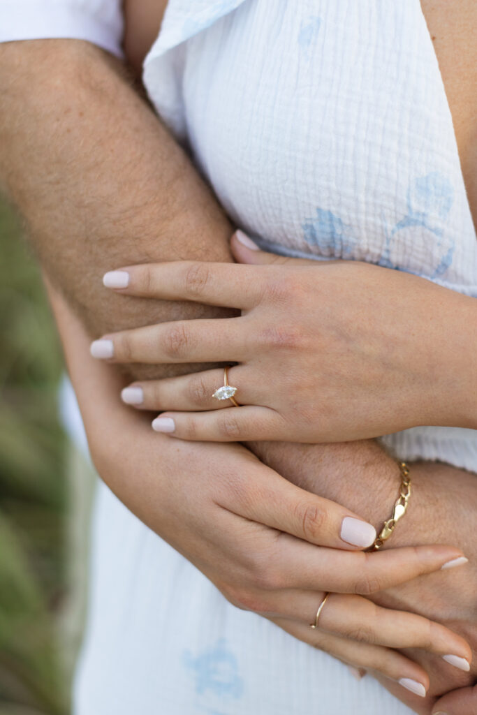 Close-up of engagement ring on the bride-to-be’s hand in Cocoa Beach.