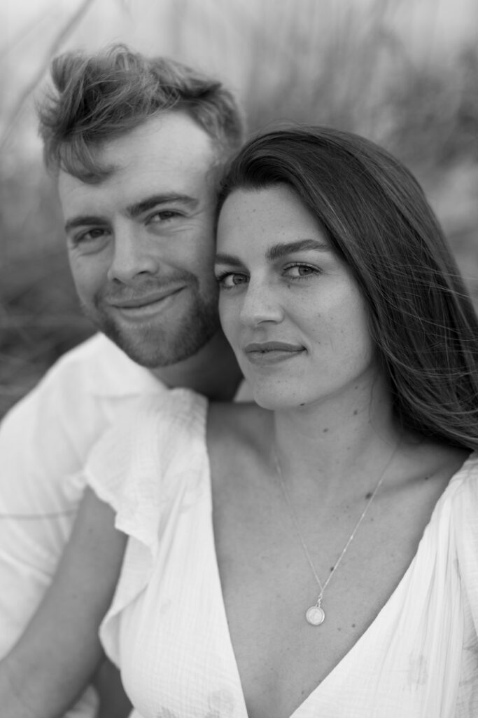 Romantic close-up of couple embracing on Cocoa Beach at sunset, photographed by The Deans Photo, showcasing love and natural beauty.