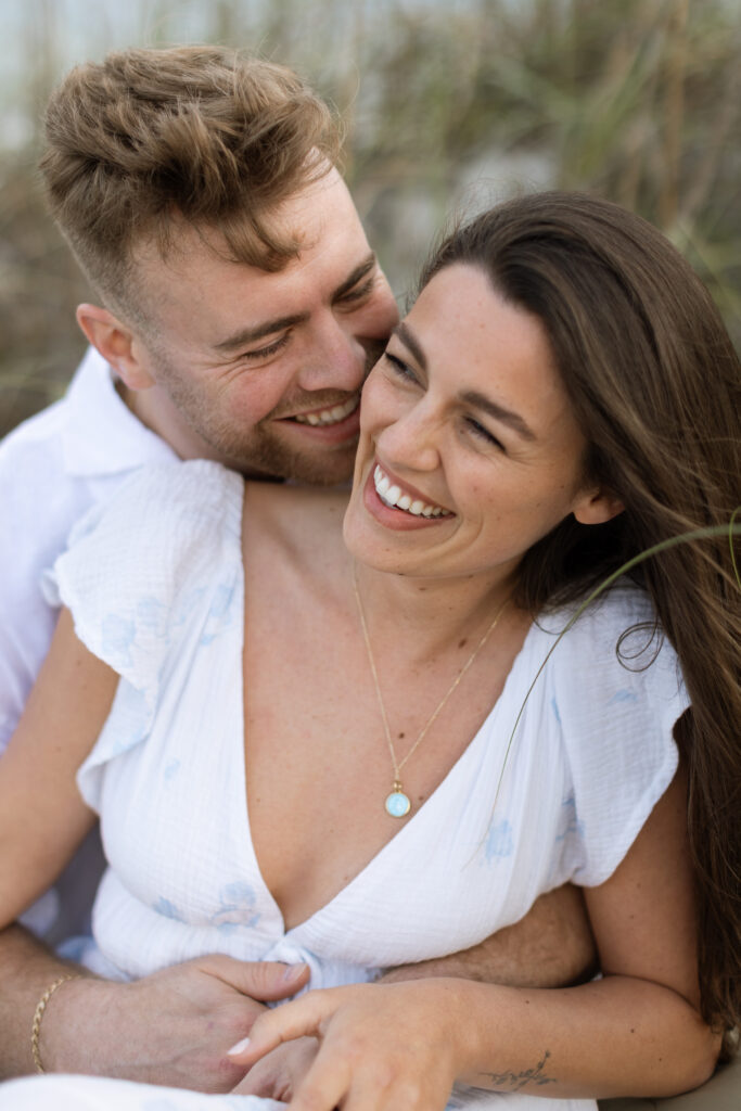 Engaged couple enjoying a fun, intimate moment on Cocoa Beach at sunset, beautifully captured by The Deans Photography.