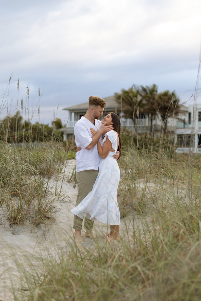 Candid photo of couple laughing on Cocoa Beach at sunset, captured naturally by The Deans Photography during golden hour.