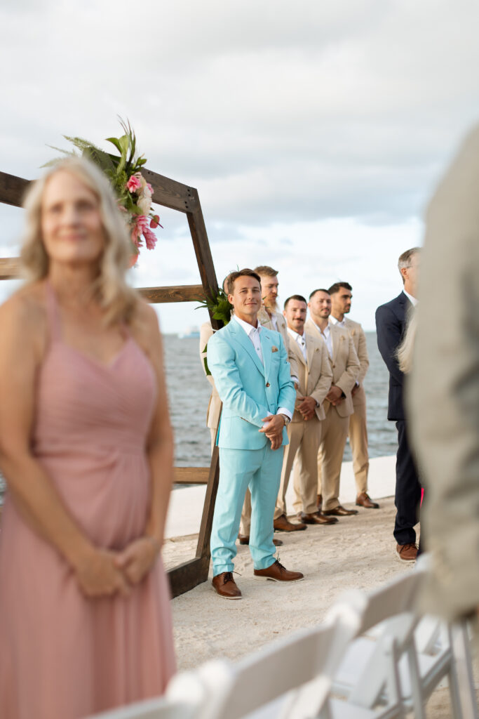 Groom watching his bride walk down the isle at the Reef House in Key Largo, Florida photographed by The Deans Photography.