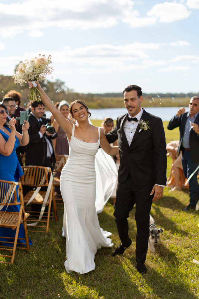 Happy couple walking down the aisle at the lakeside wedding in St. Cloud, Florida