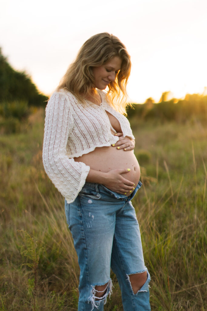 Expecting mother in a field in Central Florida, photographed by The Deans Photography.