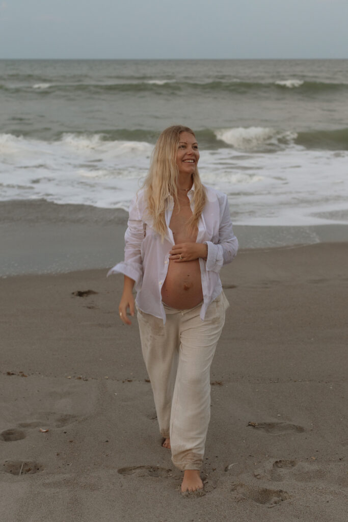 Expecting mother enjoying maternity photoshoot outdoors during golden hour in Cocoa Beach, Florida.