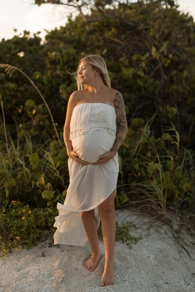 Pregnant woman in a beautiful flowing dress during outdoor maternity photo session in Central Florida photographed by the deans photography.