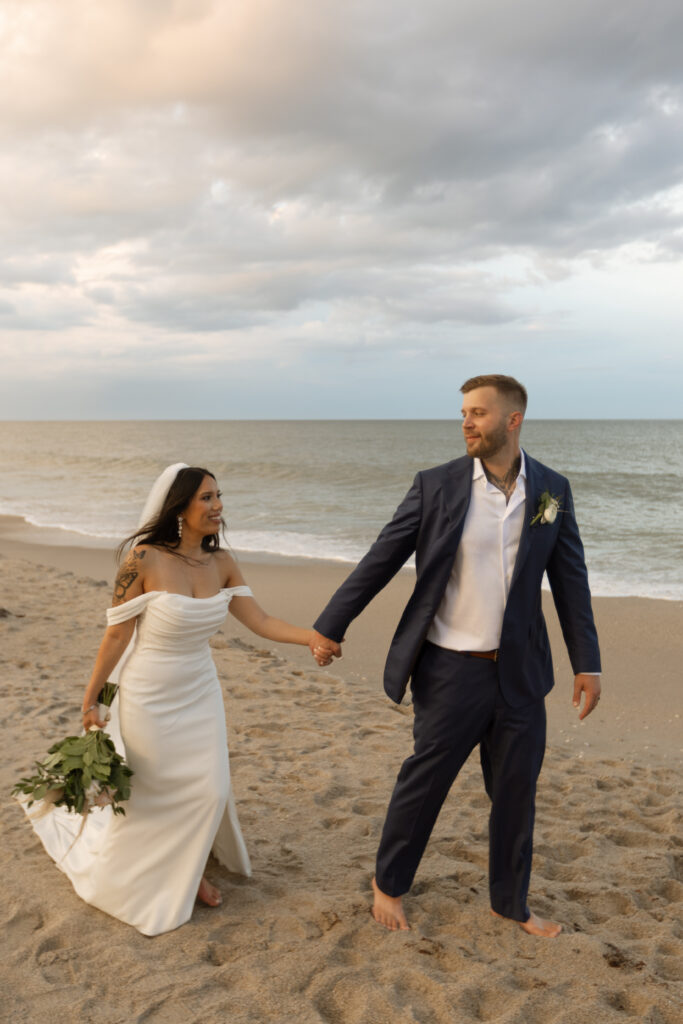 Intimate moment of couple walking by the beach, photographed by The Deans Photography.