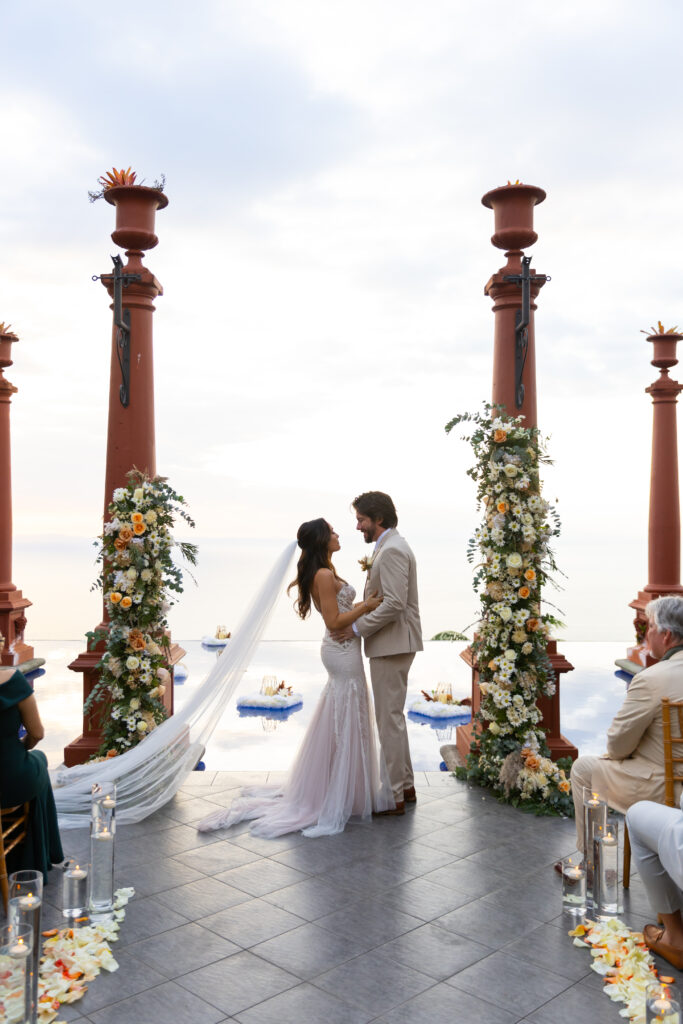 Bride and groom sharing a romantic moment on the cliffside at Villa Caletas in Costa Rica, captured by The Deans Photography.