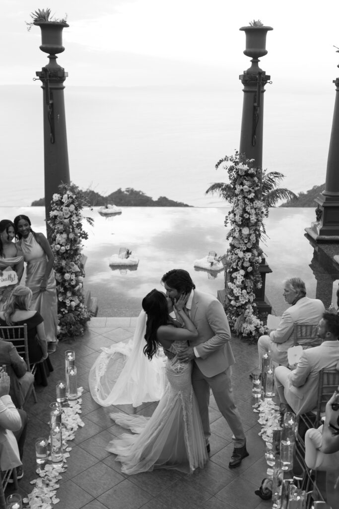 Elegant wedding ceremony setup with tropical flowers and ocean backdrop at Villa Caletas, Costa Rica, photographed by The Deans Photography.