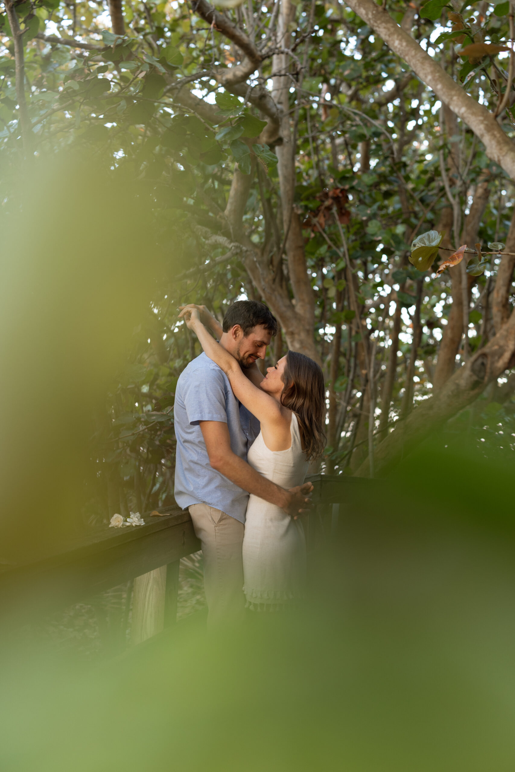 Engaged couple embracing on the boardwalk in Melbourne Beach, Florida.