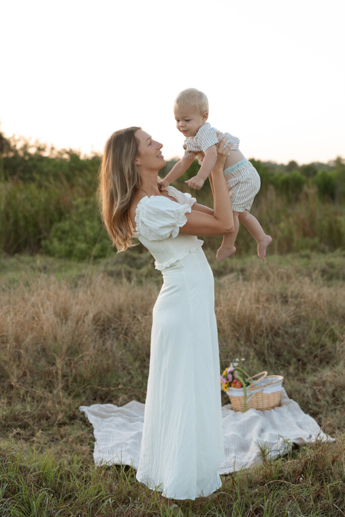 Mother wearing textured linen dress during outdoor motherhood photo session.