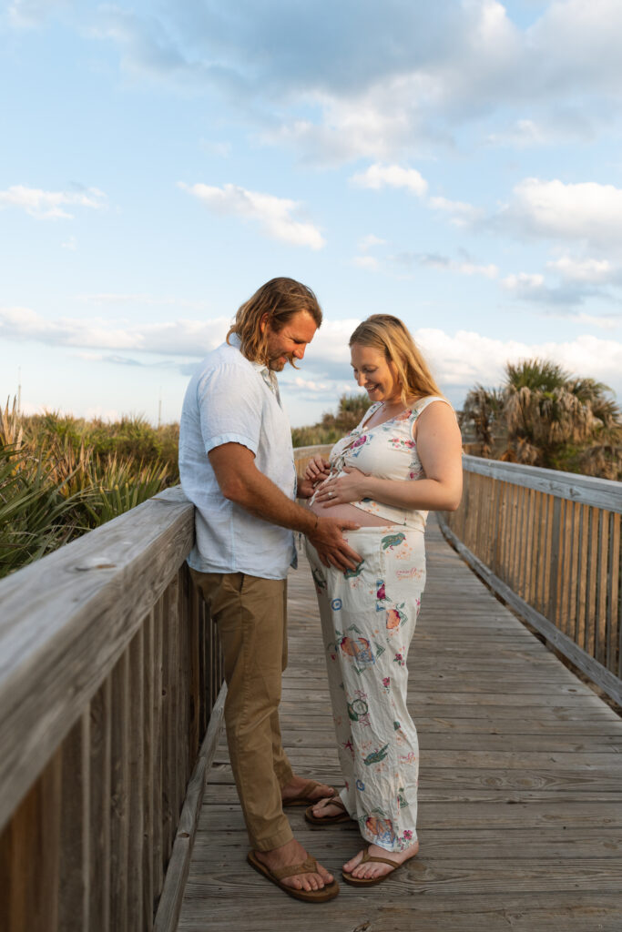 Couple enjoying sunset during their Cocoa Beach maternity session