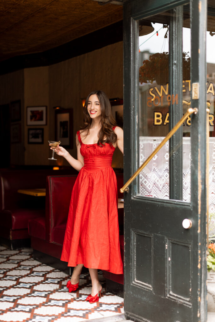 Future bride in pops of red during her engagement session in a New York bar