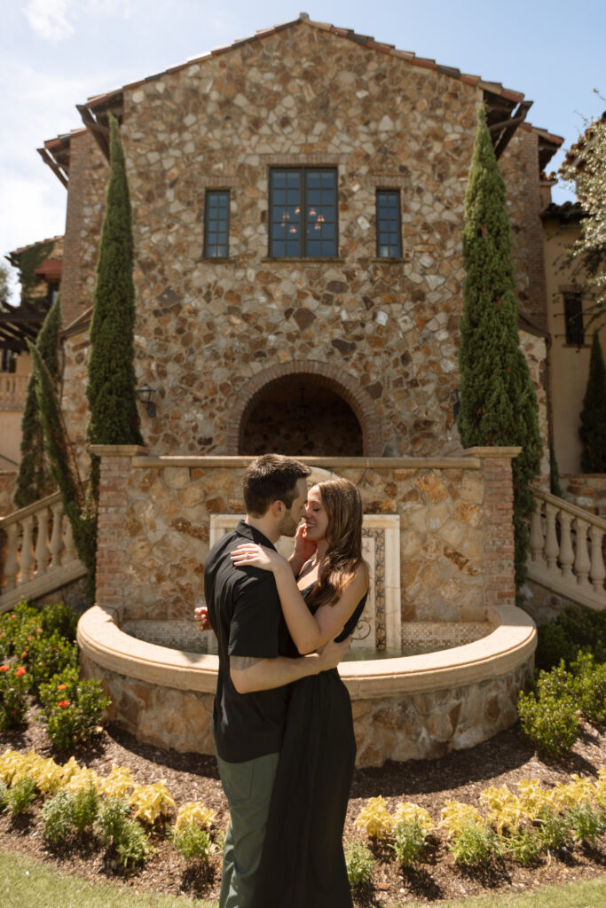 Stylish couple in front of a Mediterranean wall in Orlando, dressed in chic, coordinated outfits in black tones.