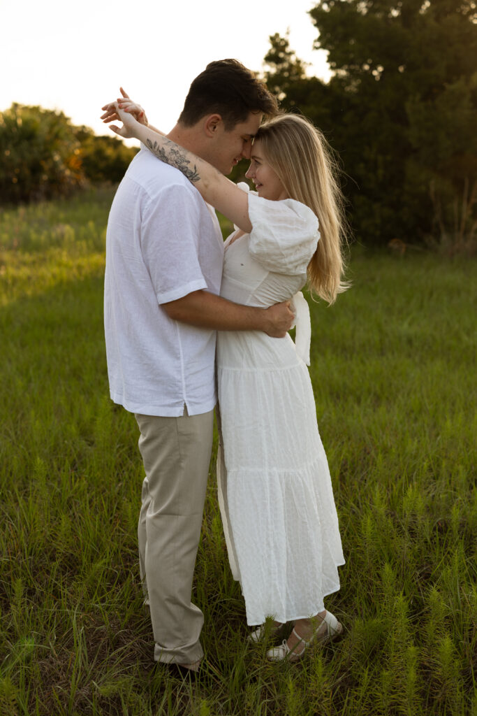 Engaged couple together in an open field during a laid-back outdoor engagement session