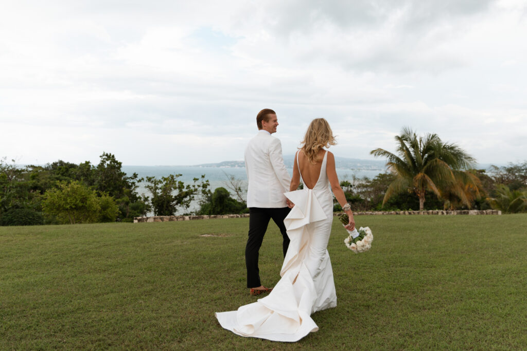 Bride and groom holding hands by the Caribbean Sea in Jamaica