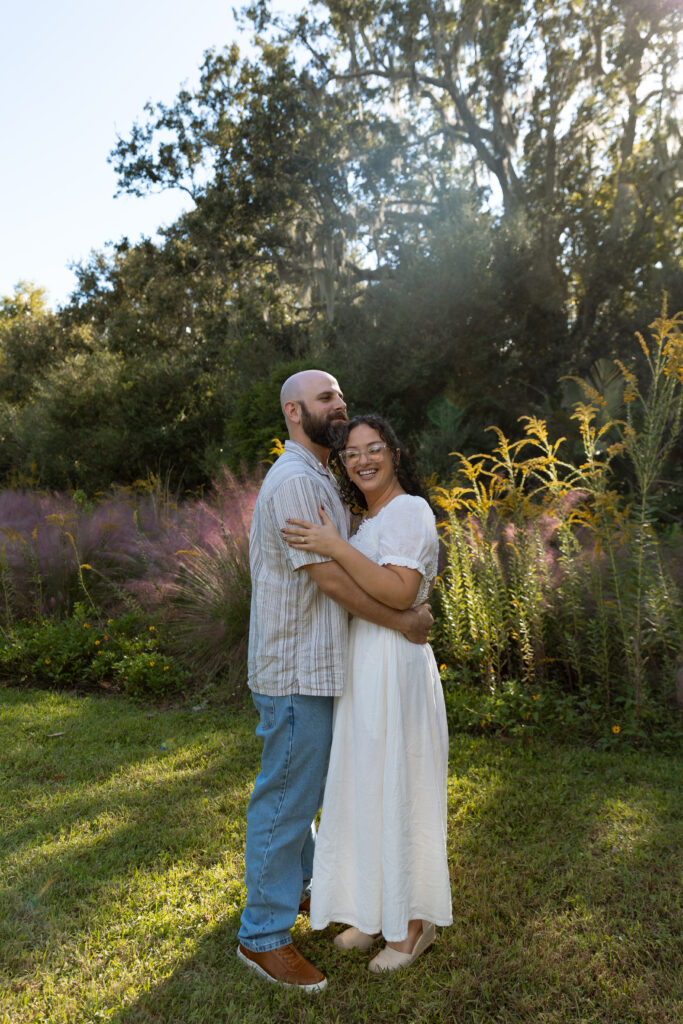 Couple walking through blooming garden path at Leu Gardens during Central Florida engagement session.